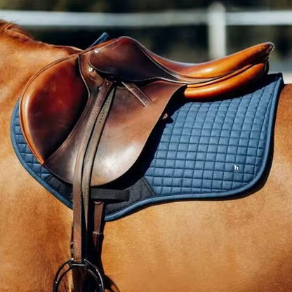 Brown leather saddle on a horse with a blue saddle pad