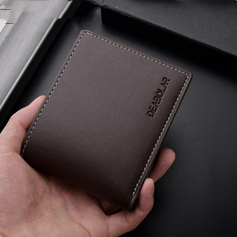Brown leather wallet held in a hand with a dark background