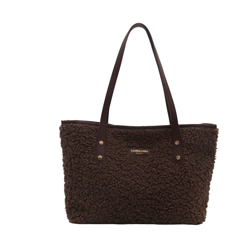 Brown textured tote bag with visible brand name on a white background