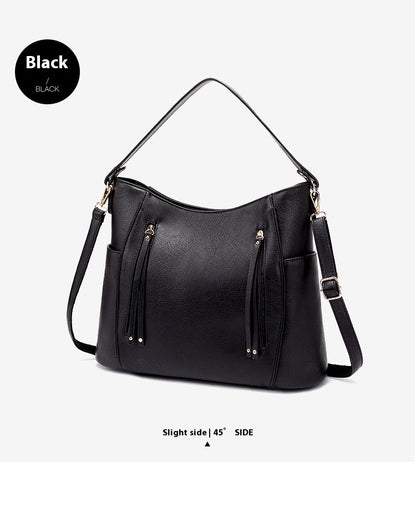 Black handbag with gold accents on a light gray background