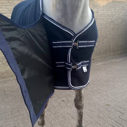 Navy blue equestrian blanket with white trim on a horse