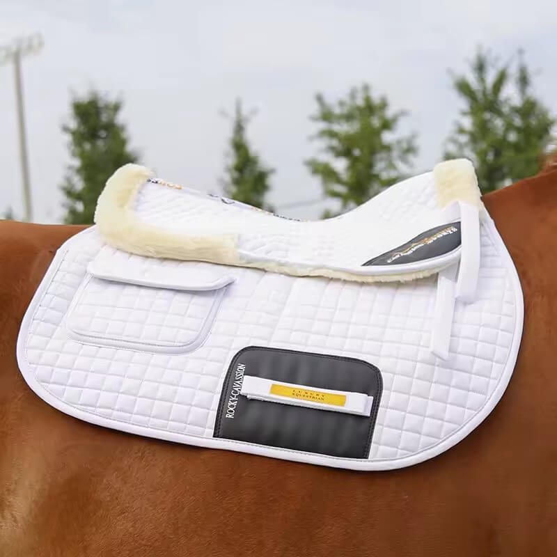 White quilted saddle pad on a horse with a blurred natural background